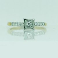 SR1611HN 18CT 2T GOLD WITH 1 PRINCESS CUT DIAMOND BEZEL SET CENTRE ROUND DIA CLAW SET ON THE SHANKS