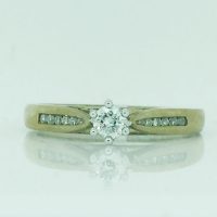 01-086 9CT 2T ROUND CLAW DIA SET IN CENTRE WITH SML DIA CHANNEL SET ON BAND RING